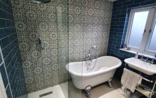 blue luxury bathroom in surrey loft conversion 10 large family bathroom completed in surrey home extension with blue betro tiles and feature pattern tiled wall with freestanding bath and walk in rainfall shower