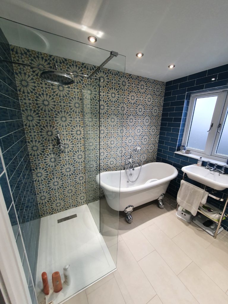 blue luxury bathroom in surrey loft conversion 10 large family bathroom completed in surrey home extension with blue betro tiles and feature pattern tiled wall with freestanding bath and walk in rainfall shower