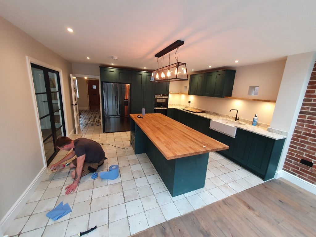 completed green kitchen in strawberry hill home renovation Dark Green Kitchen with belfast sink and large island