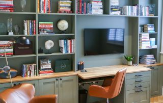 Home office with green built in shelving and bespoke carpentry