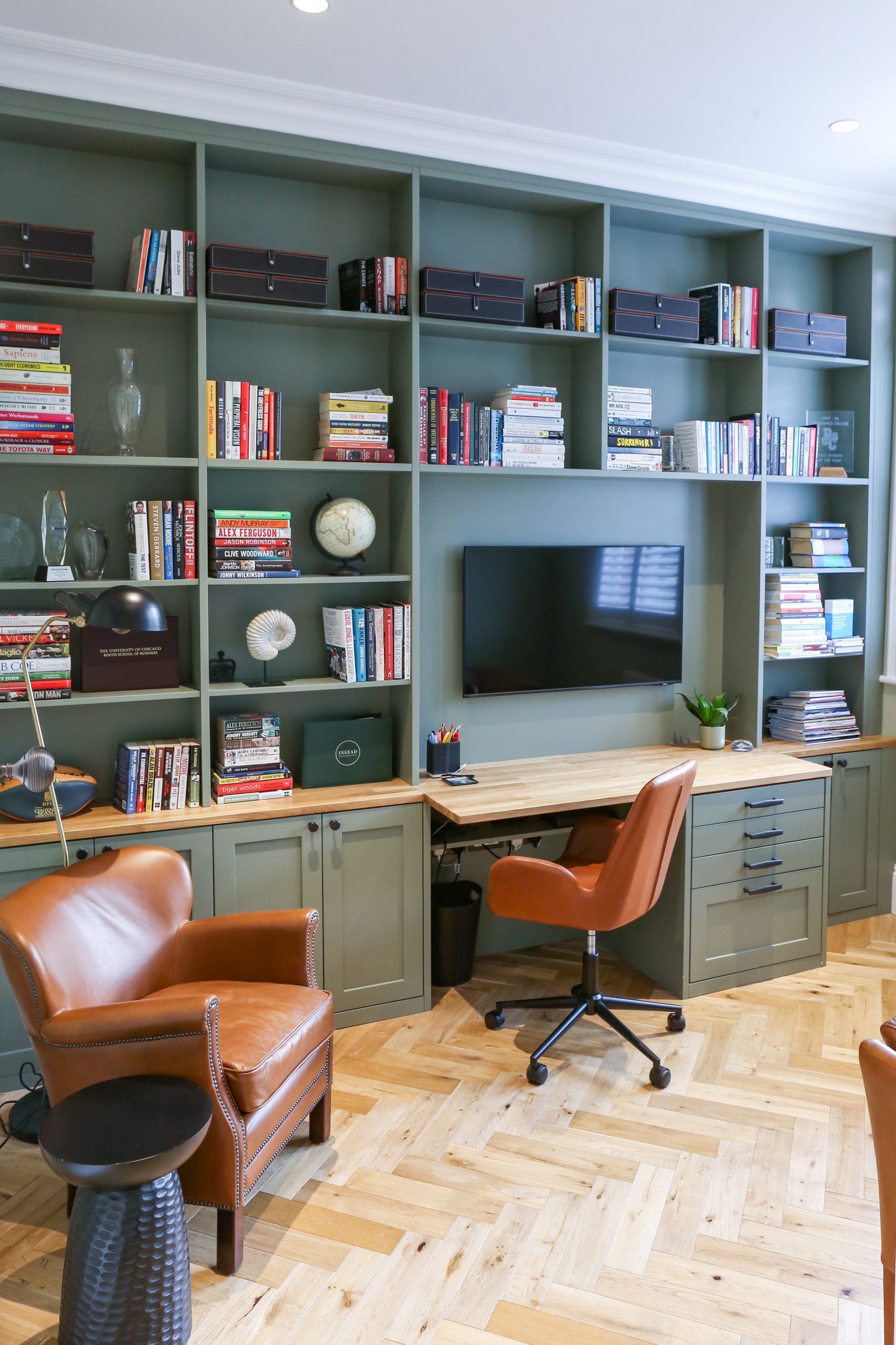 Home office with green built in shelving and bespoke carpentry