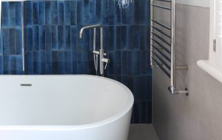 Blue tiled bathroom and soaking tub fitted by Top Grade Build