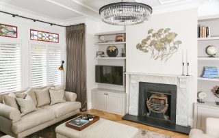 Marble fireplace and built-in alcove media shelving by Top Grade
