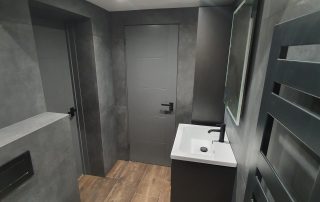 doorway view of grey modern bathroom Dark sophisticated luxury modern bathroom