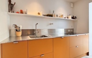 bold yellow kitchen with industrial style worktops and open shelving